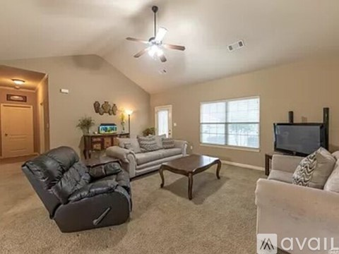 A living room with a black leather chair and a wooden coffee table.