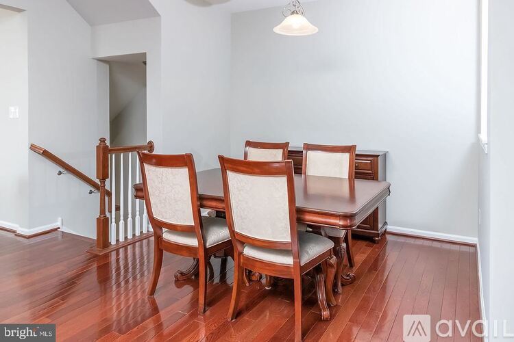 A room with a wooden floor and a set of chairs and a table.