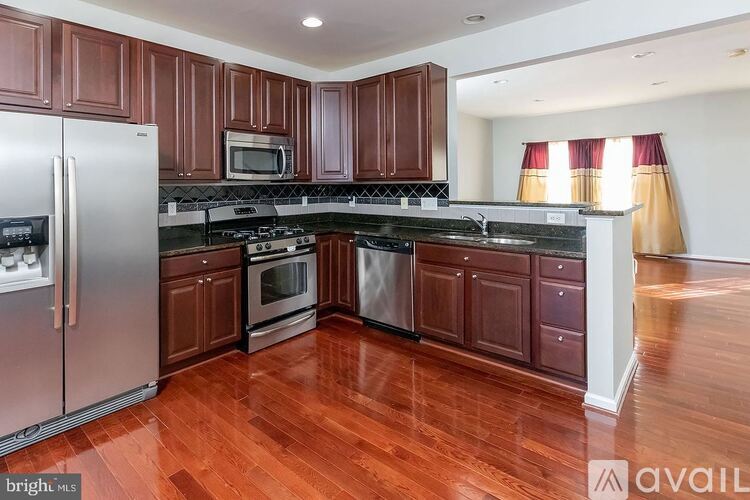 A kitchen with wooden cabinets and a stainless steel refrigerator.