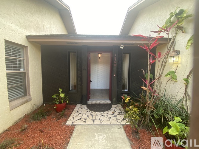 A house entrance with a red door and a tiled walkway.