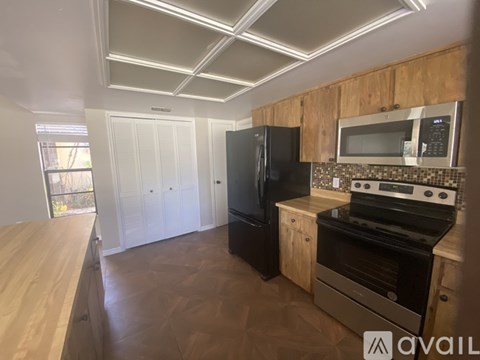 A kitchen with wooden cabinets and black appliances.