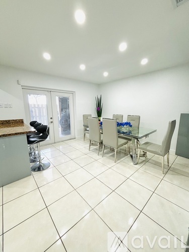 A kitchen with a table and chairs.