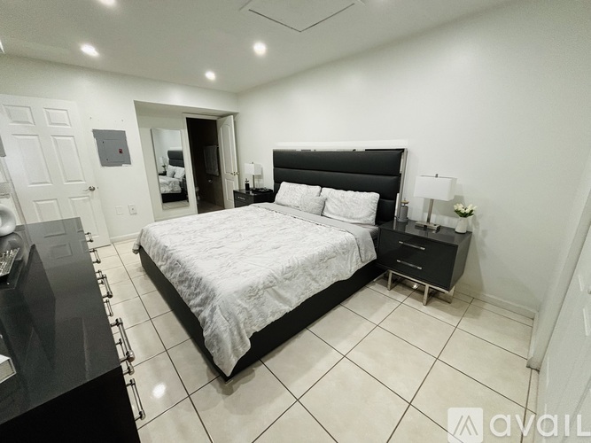 A bedroom with a large bed and a black headboard.