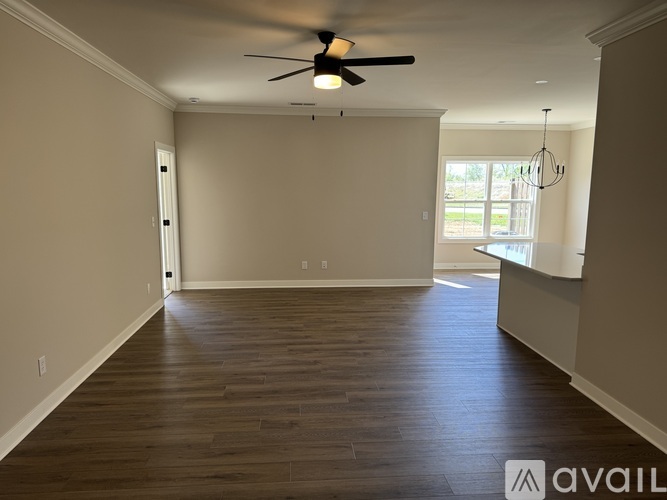 A spacious room with a ceiling fan and wooden flooring.