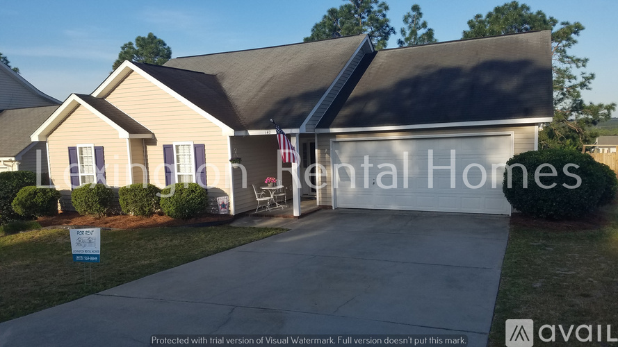 A house with a sign that says "For Sale" in front of it.