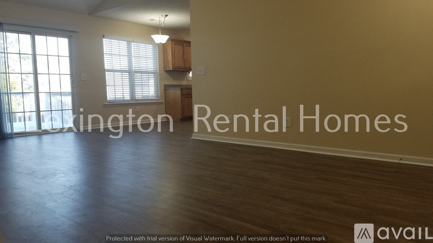 A spacious room with wooden floors and a large window is available for rent.