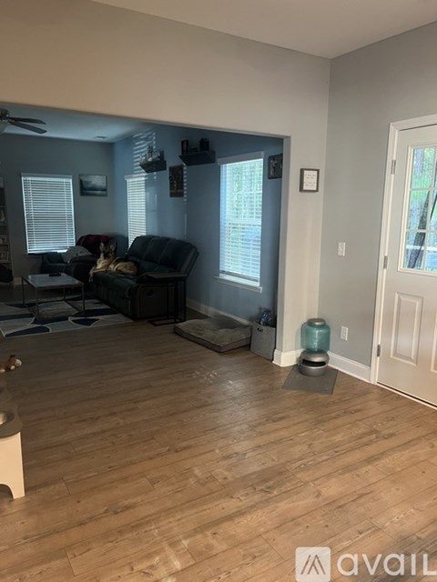 A living room with a couch and a fan.