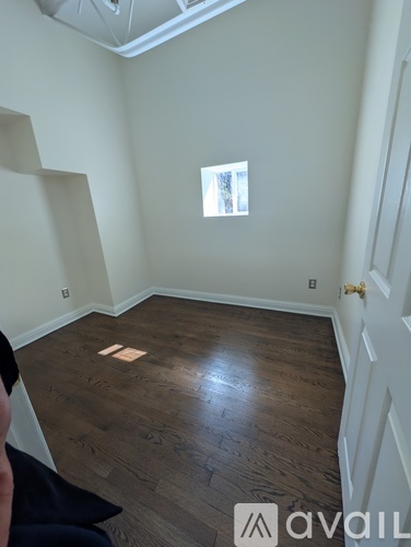 A room with wooden flooring and a window.