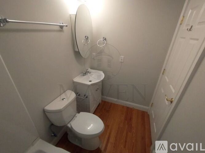A white toilet and sink in a small bathroom.