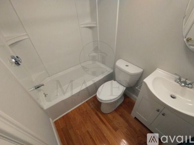 A white toilet sits next to a bathtub in a bathroom.