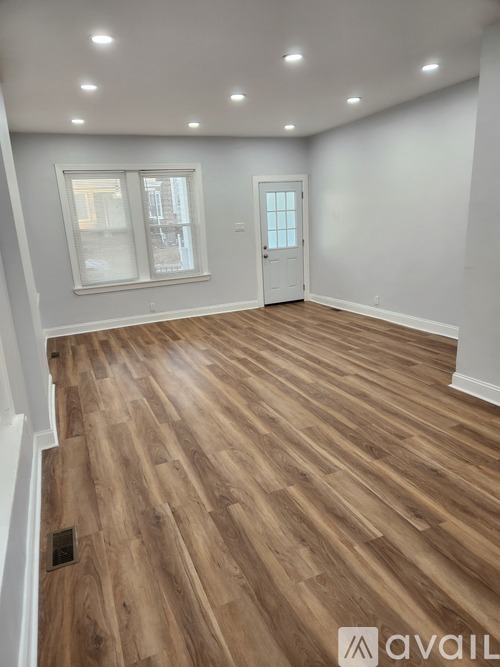 A room with wooden flooring and a white door.