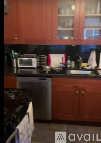 A kitchen with red cabinets and a black countertop.