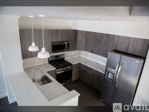 A modern kitchen with a refrigerator, sink, and stove.