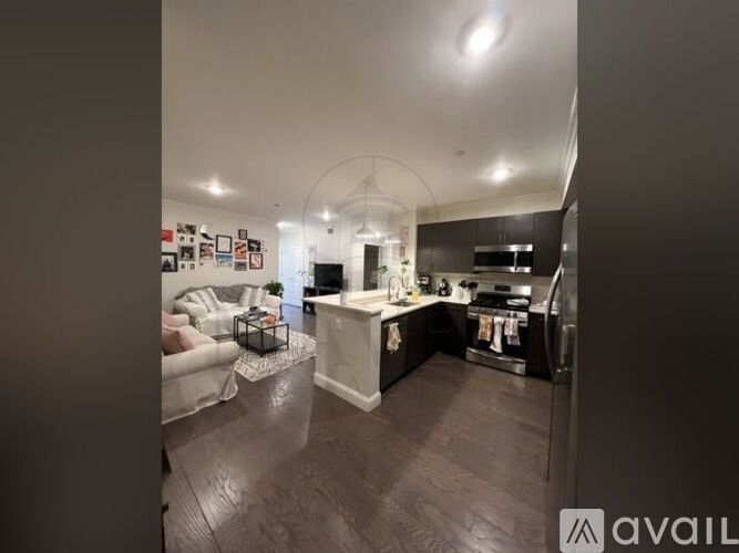 A modern kitchen with dark wood floors and a white island.