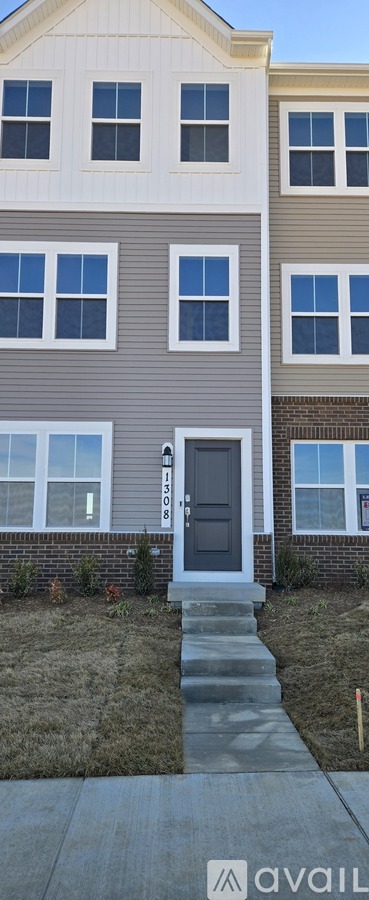 A grey house with a black door and a small step leading to the entrance.