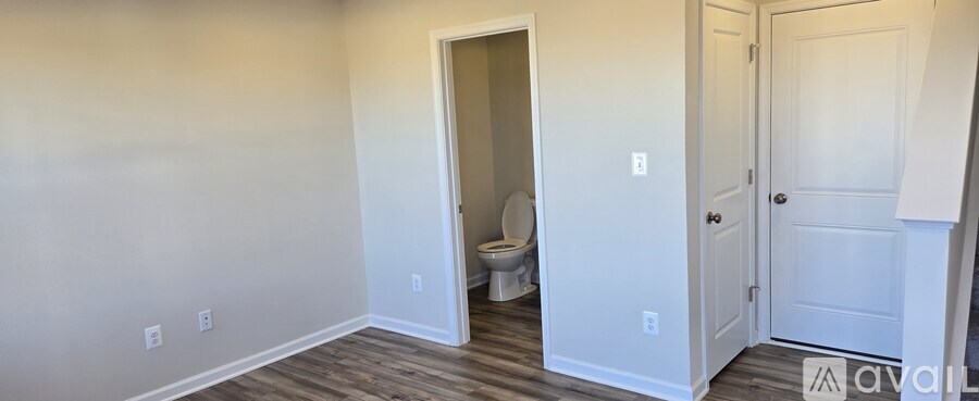 A room with a toilet visible through an open door.