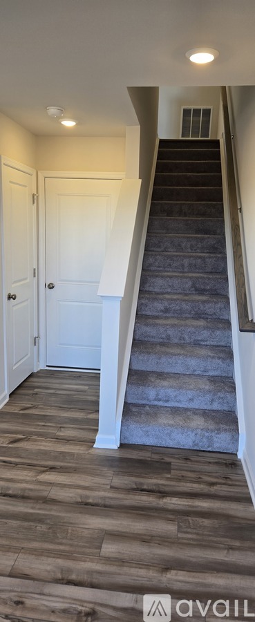 A staircase with a carpeted runner and wooden steps.