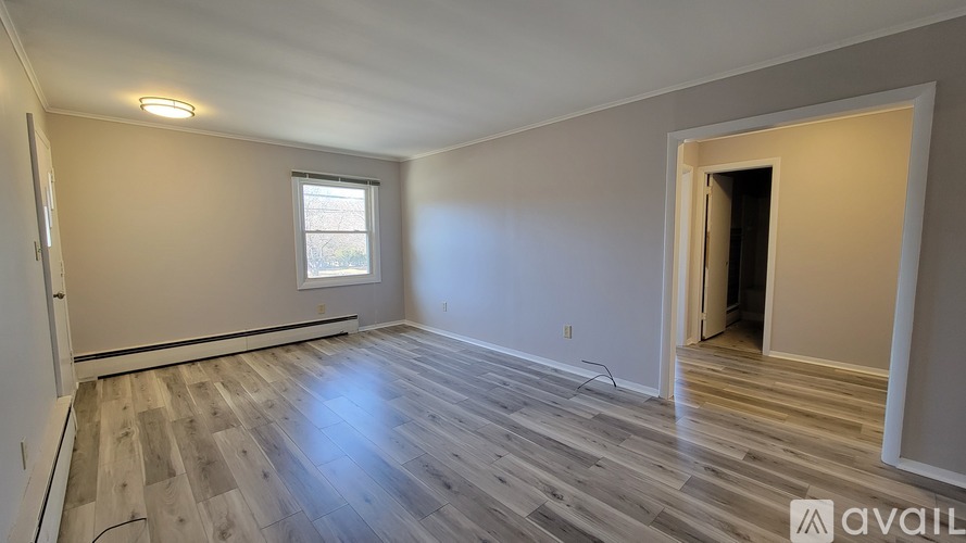 A room with wooden flooring and a window is available for rent.