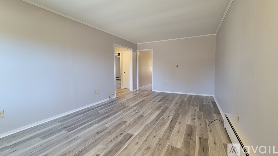 A room with wooden flooring and two doors.