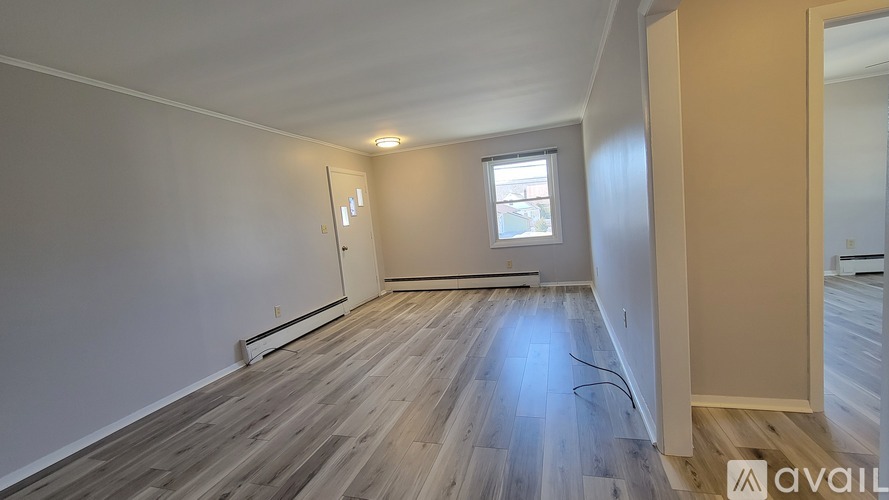 A room with wooden flooring and a window.