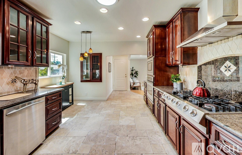 A kitchen with brown cabinets and a tile backsplash.