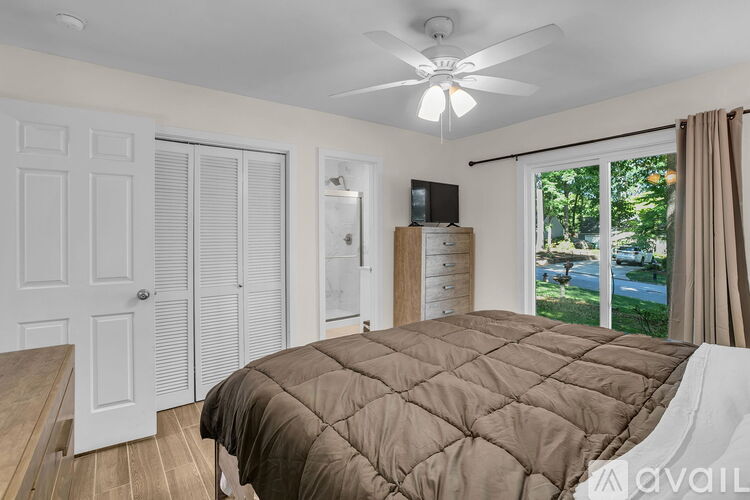 A bedroom with a large bed and a ceiling fan.