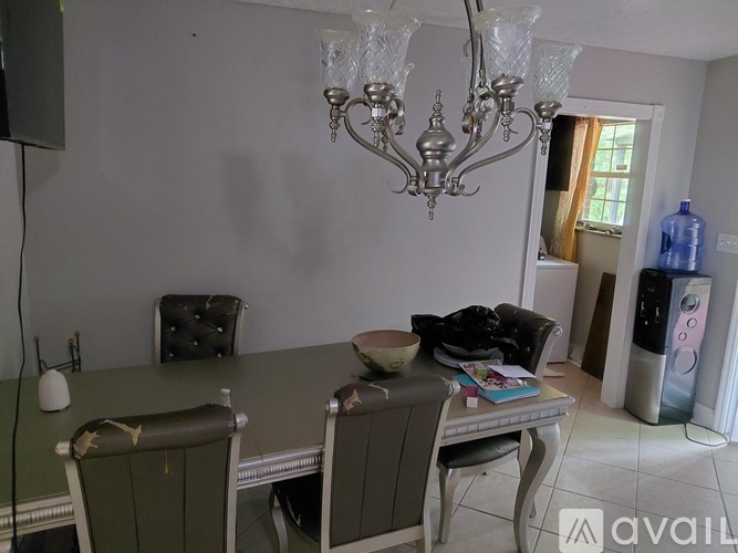 A dining room with a table, chairs, and a chandelier.