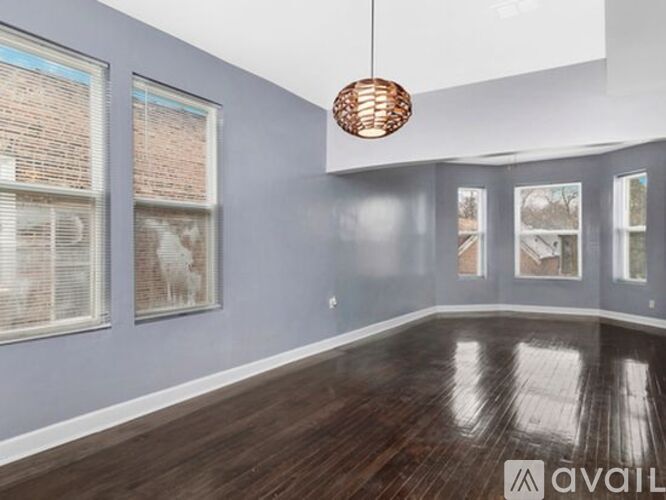 A room with wooden floors and a hanging light fixture.
