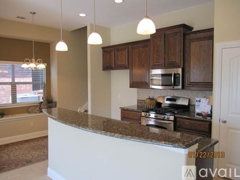 A kitchen with brown cabinets and a granite countertop.