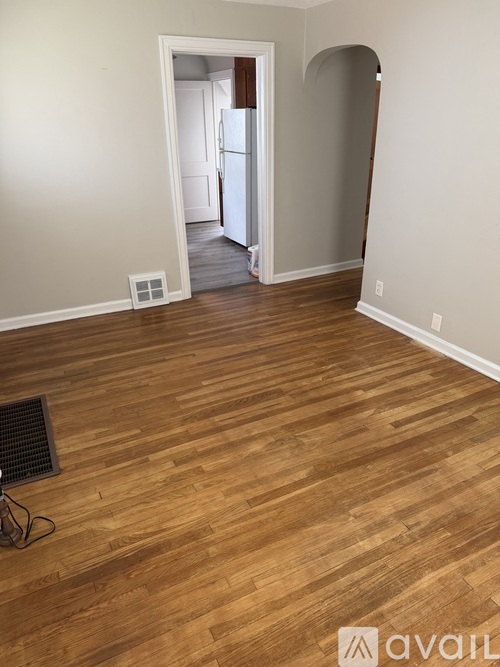 A room with wooden flooring and a white door.