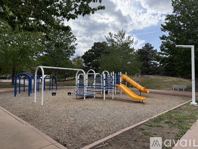 A playground with a yellow slide and blue and white equipment.