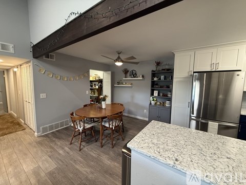 A kitchen with a table and chairs in the middle of the room.
