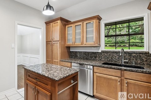 A kitchen with wooden cabinets and granite countertops.
