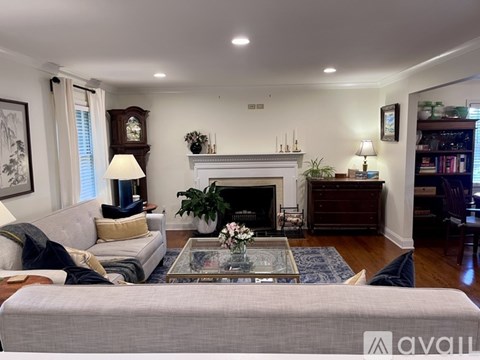 A living room with a grey couch, a fireplace, and a painting on the wall.