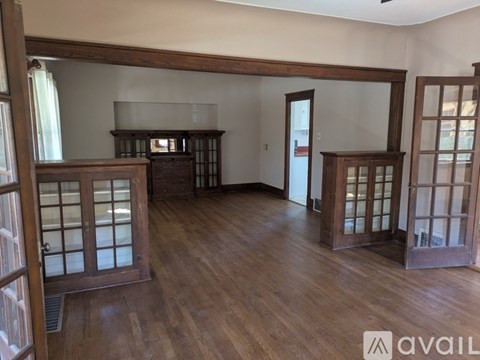 A room with wooden floors and three wooden doors.
