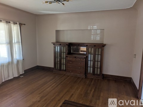 A room with wooden floors and a cabinet with glass doors.