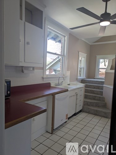 A kitchen with white cabinets and a red counter.