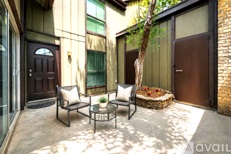 A patio with a table and chairs is in front of a building.