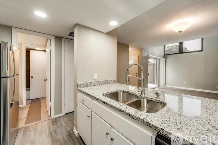 A modern kitchen with granite countertops and stainless steel appliances.