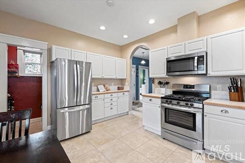 A kitchen with white cabinets and stainless steel appliances.