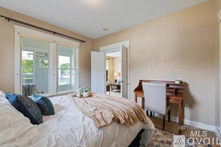 A bedroom with a bed, desk, and chair.