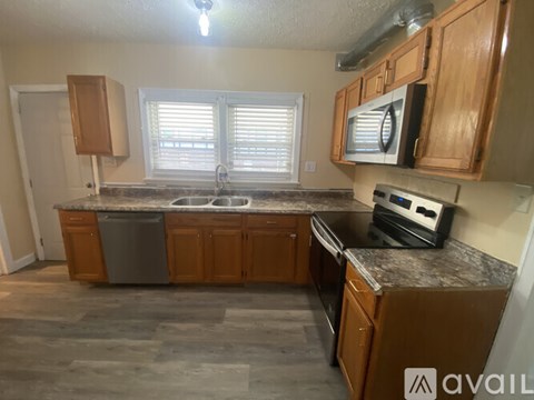 A kitchen with wooden cabinets and granite countertops.