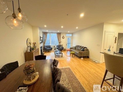 A well-lit living room with a wooden dining table and a couch.