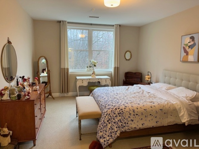 A bedroom with a large bed and a window with curtains.