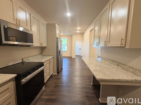 A kitchen with a black stove top oven and white cabinets.
