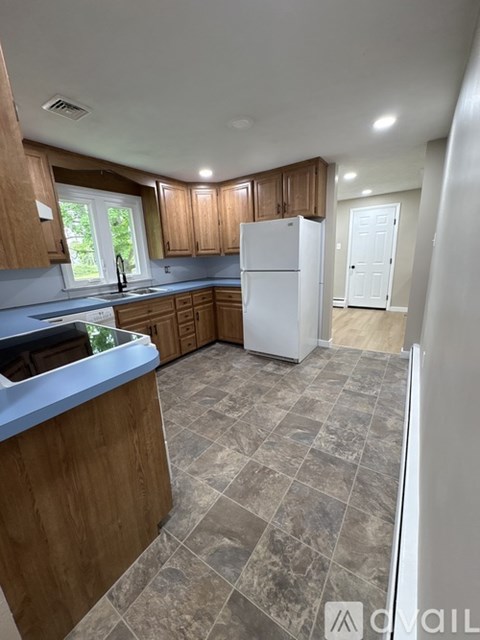 A kitchen with wooden cabinets and a white refrigerator.