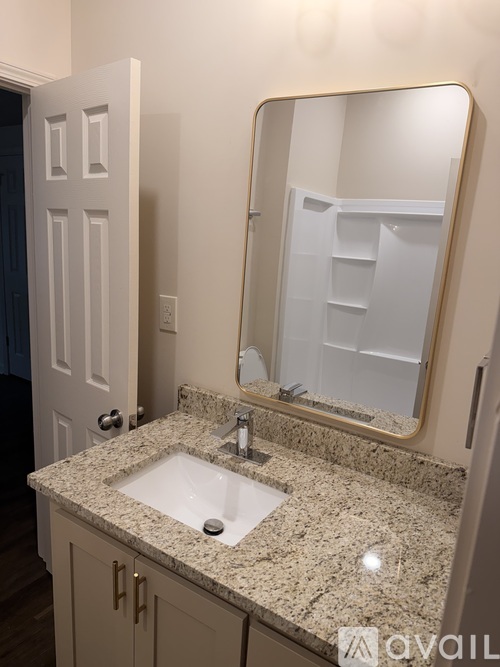 A bathroom with a sink, mirror, and cabinet.