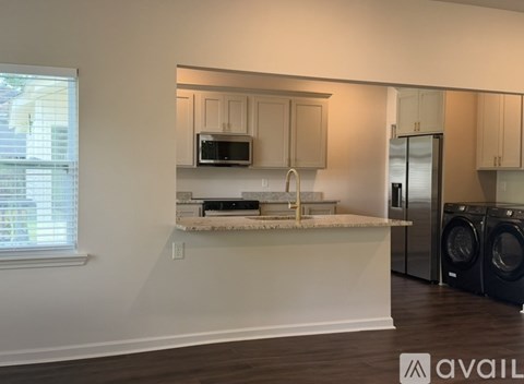A kitchen with a washer and dryer in the corner.