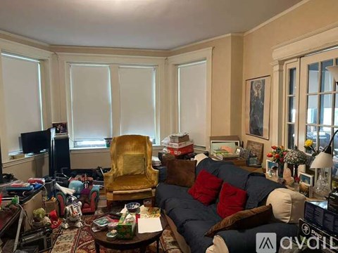 A living room with a blue couch and a yellow chair.
