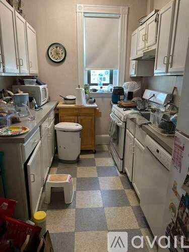 A kitchen with a checkered floor and a window.
